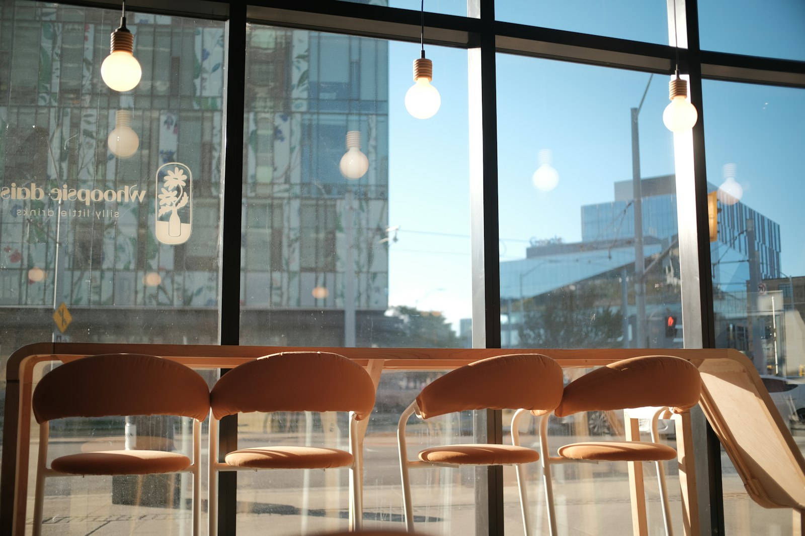 Interior luminoso de día con banquetas y ventanales urbanos