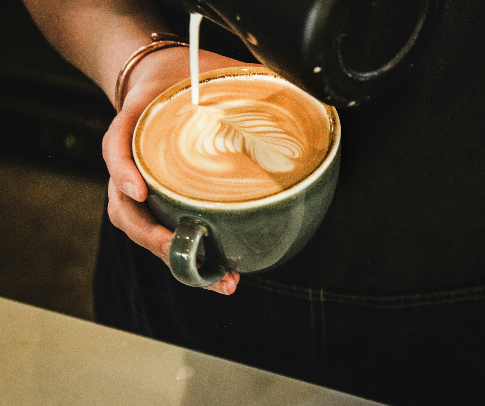Barista sirviendo café con arte latte