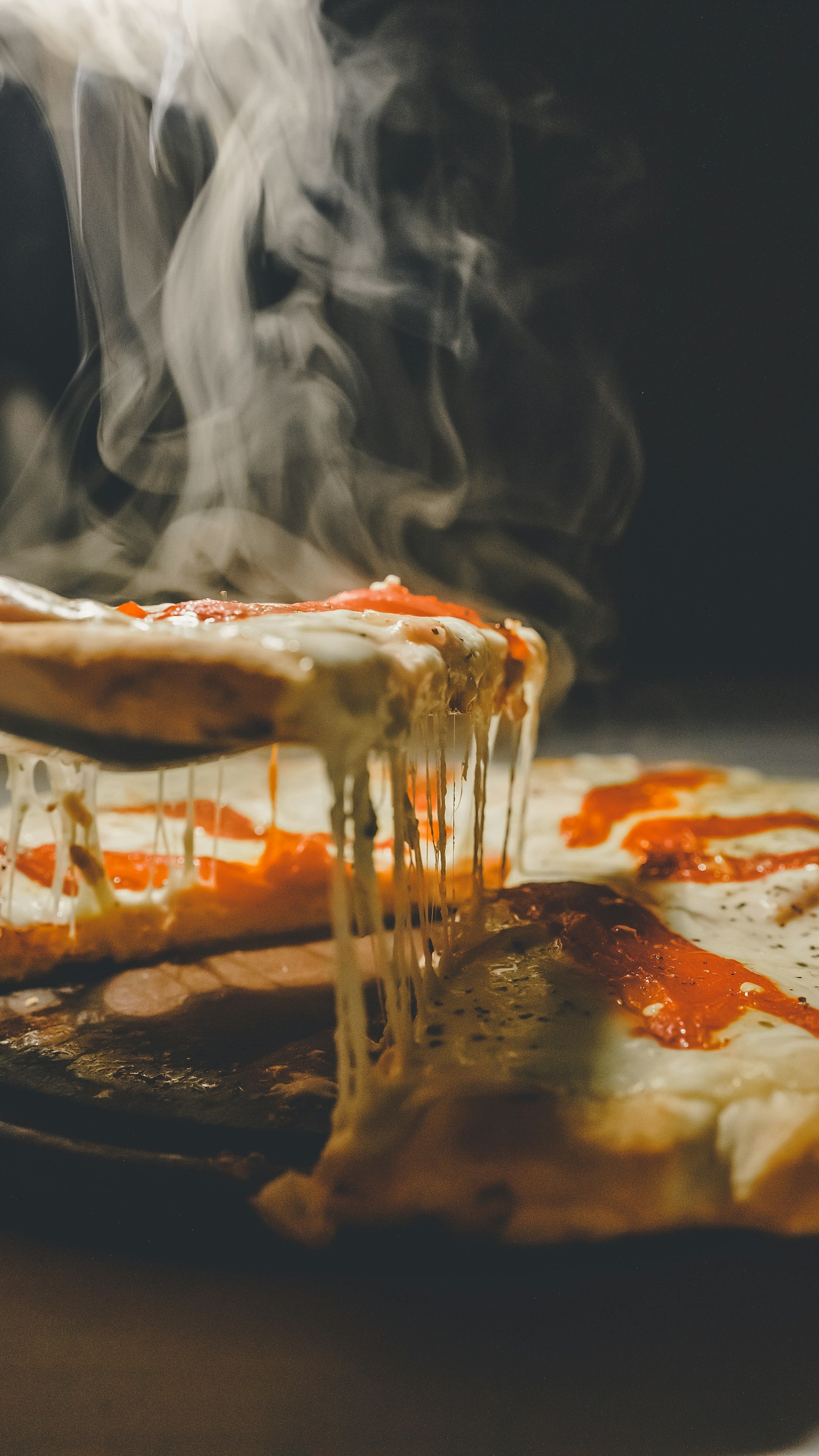 Porción de pizza con queso derretido y vapor